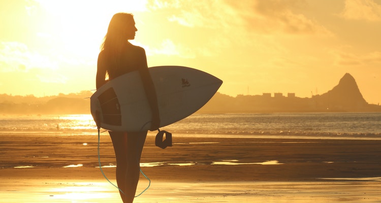 female surfer walking with board